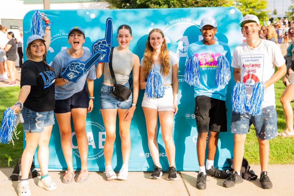 six students standing in front of CAB backdrop at Laker Kickoff photo booth